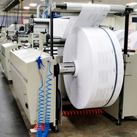 Large roll of paper being fed to a printer