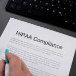 Image: Person looking at a document that says hipaa compliance
