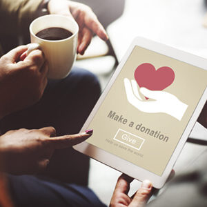 person holding a tablet with a donation request and a coffee